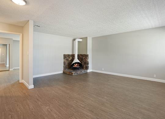 A room with a fireplace and wood flooring.