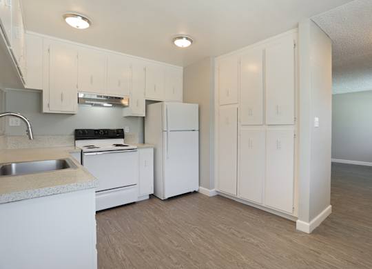 A kitchen with white cabinets and appliances.