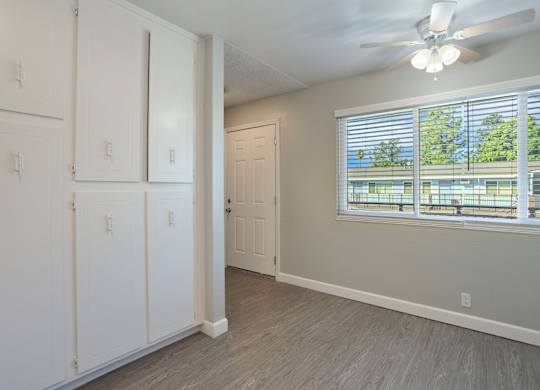 A room with a window and a ceiling fan.
