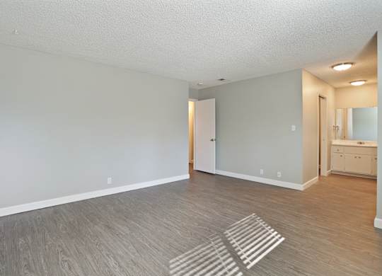 A room with a wooden floor and a white wall.