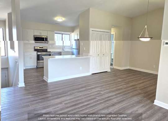 A spacious apartment kitchen with white appliances and a large island.