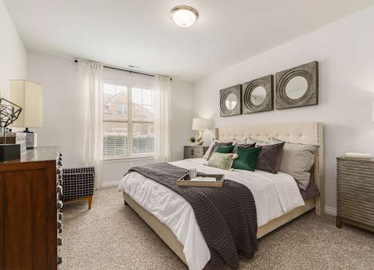 a bedroom with a bed and two mirrors on the wall