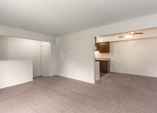 A large, empty room with a carpeted floor and white walls.