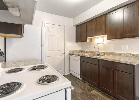 A kitchen with a white stove top oven and white refrigerator.