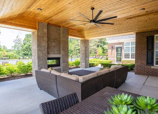 A patio with a couch and a ceiling fan.