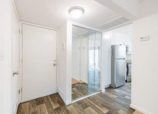 A white door is in a room with a wooden floor.