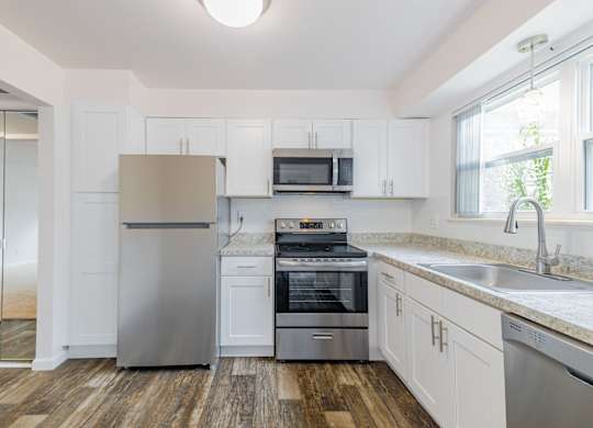 A kitchen with white cabinets and stainless steel appliances.