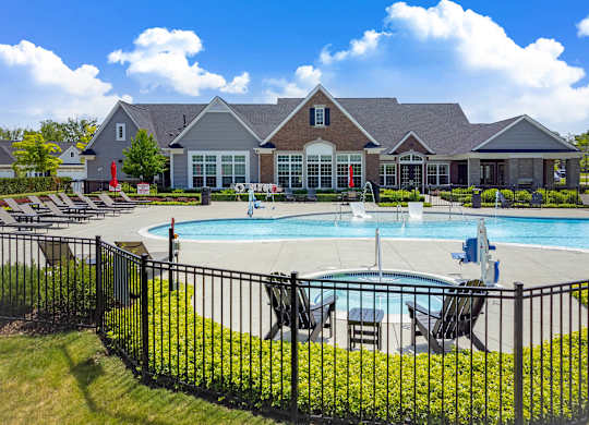 A large house with a pool in front.