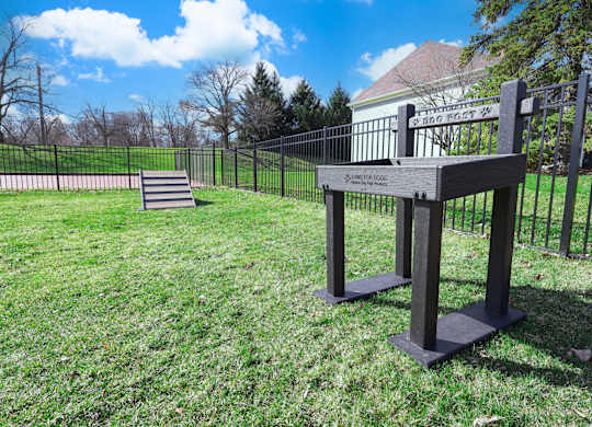 A black metal fence surrounds a grassy area with a sign that reads "Amistad Boundary".