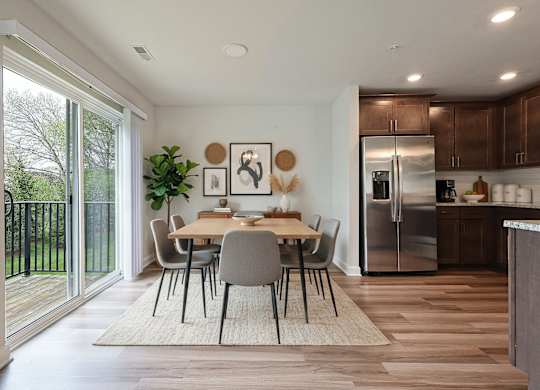 A modern kitchen with a dining table and chairs in the middle of the room.