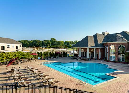 an aerial view of a swimming pool with a house and a resort style pool