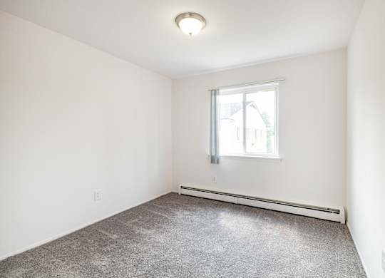 A room with a window and a radiator on the wall.