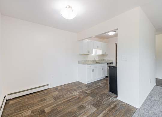 A room with a wooden floor and white walls.
