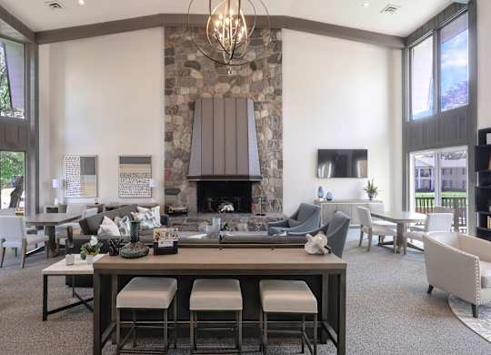 A modern dining room with a stone fireplace and a chandelier.