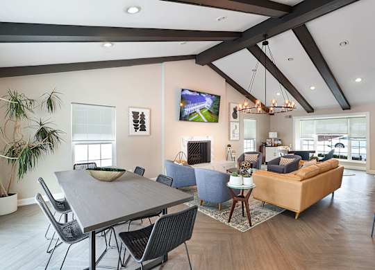 A modern living room with a large grey table and a blue sofa.