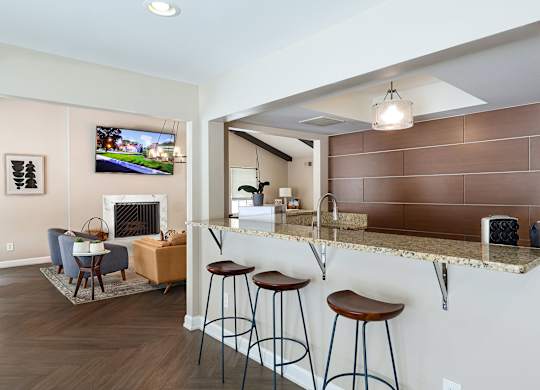 A living room with a fireplace and a bar area.