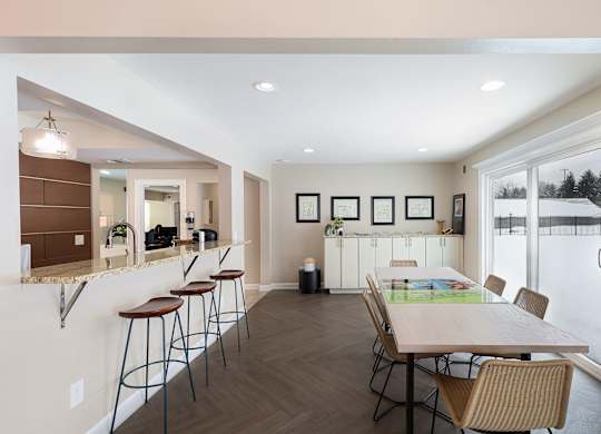 A kitchen with a table and chairs in front of a window.