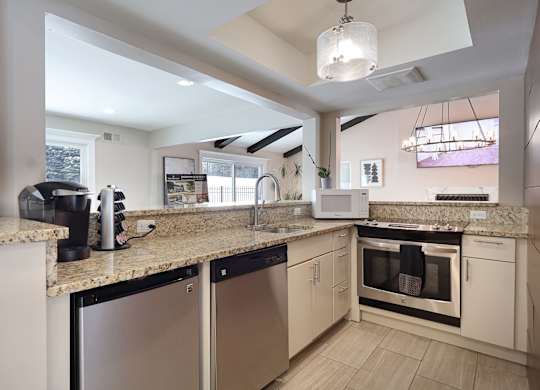 A modern kitchen with granite countertops and stainless steel appliances.