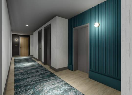 A hallway with a blue carpet and white walls.