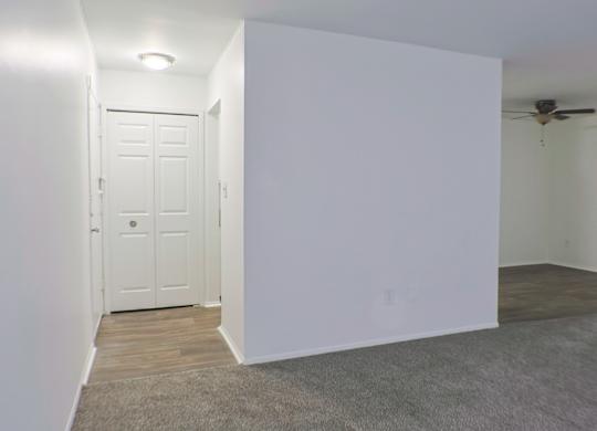 A white door is in a room with a ceiling fan.