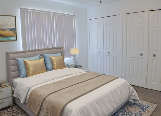 A bedroom with a large bed and a painting on the wall.