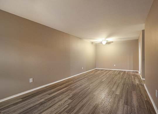 A room with wooden flooring and a light on the wall.