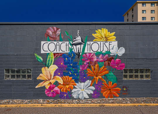 A mural of flowers surrounds the words