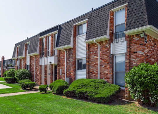A row of red brick houses with white windows and doors.
