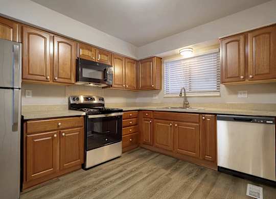 A kitchen with wooden cabinets and stainless steel appliances.