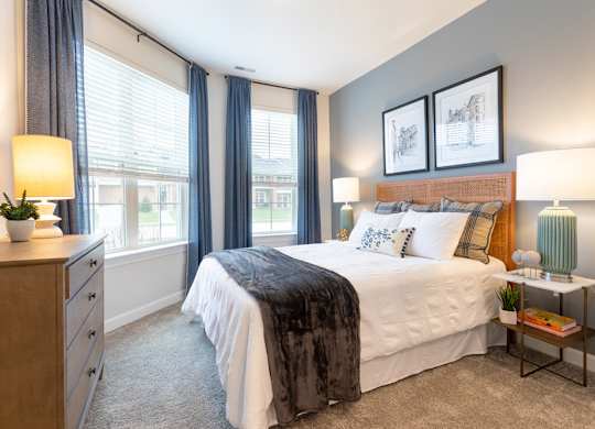 A bedroom with a large bed and a nightstand with a lamp.