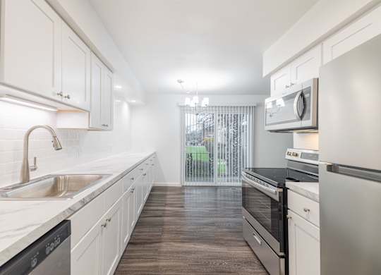 A kitchen with white cabinets and a black stove top oven.