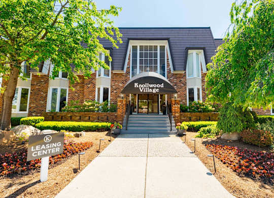 The entrance to Knollwood Village with a leasing center sign in front.