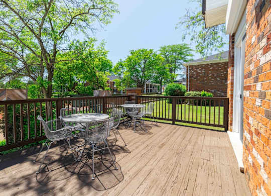 A wooden deck with a table and chairs.