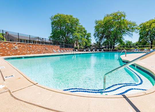 A large outdoor swimming pool with a blue line in the middle.