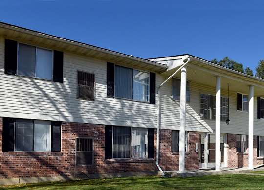 A white building with a porch and a covered walkway.