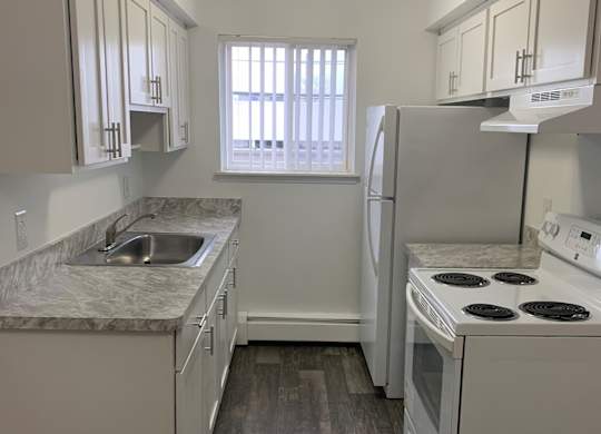 A kitchen with white appliances and cabinets.
