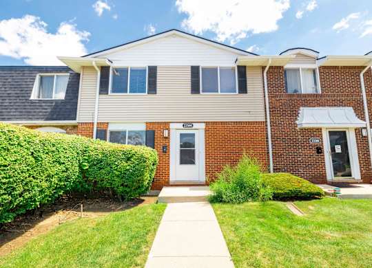 A two-story house with a white door and windows.