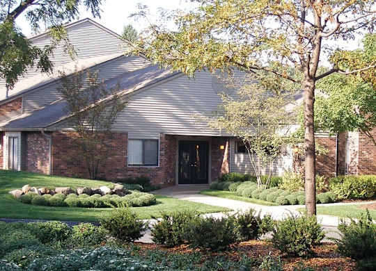 the front of a house with a yard and trees