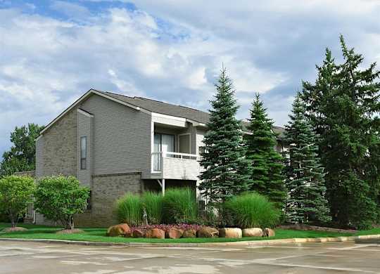 a house with a parking lot and some trees