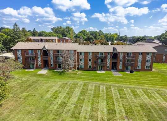 A large, multi-story building with a green lawn in front.