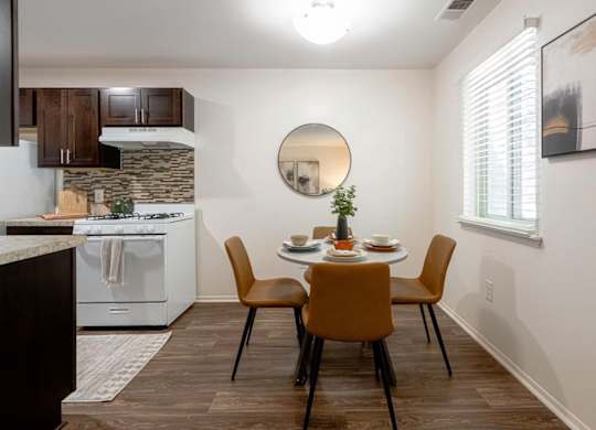 A kitchen with a table set for two and a white oven.