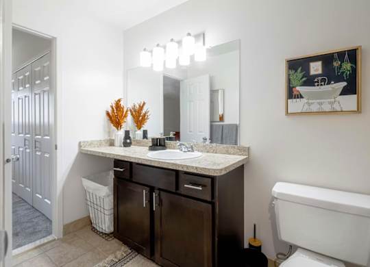 A bathroom with a white tub, sink, and a mirror.