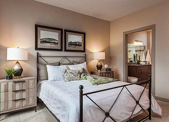 A bedroom with a bed, nightstand, and two lamps.