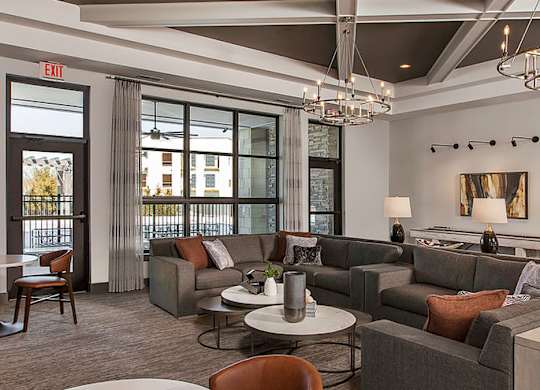 A large, modern living room with a fireplace and a view of the outside.