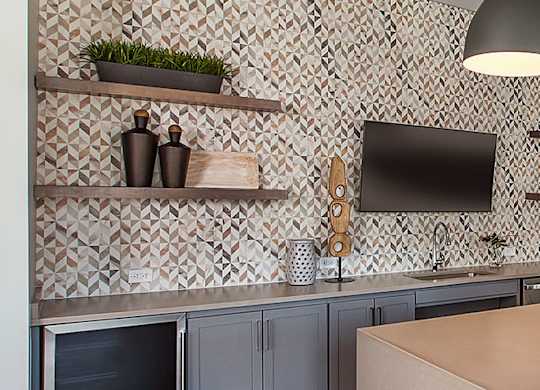 A kitchen with a brown table and grey cabinets.