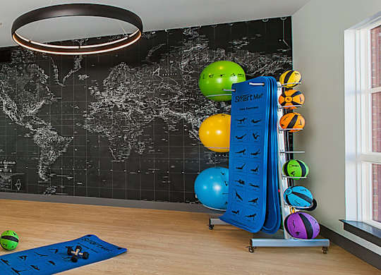 A room with a world map on the wall and exercise equipment.