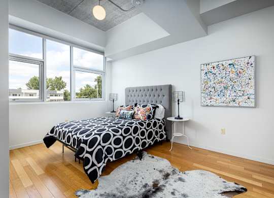 A bedroom with a large bed and a painting on the wall.