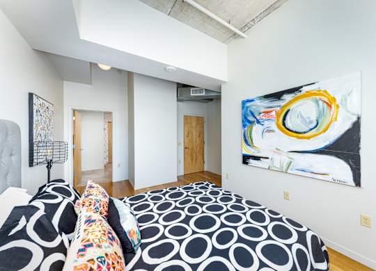 A bedroom with a bed and a painting on the wall.