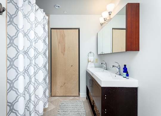 A bathroom with a wooden door and a white sink.