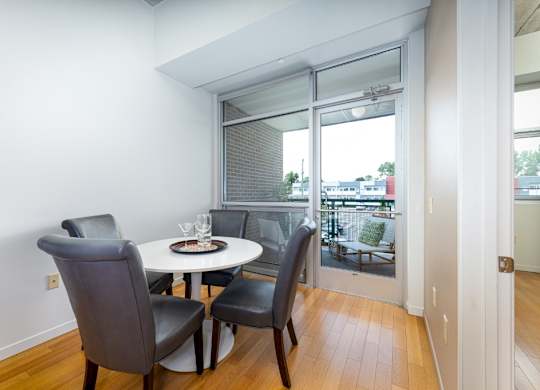 A dining room with a table and chairs.